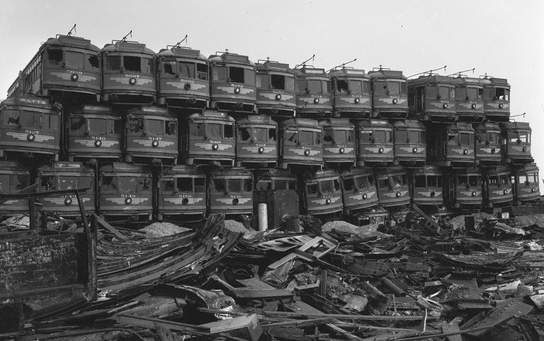 Zdjęcie przedstawia stos tramwajów usuniętych w wyniku skandalu z ulic Los Angeles, czekających niczym zabawki, aż zostaną przerobione na złom.